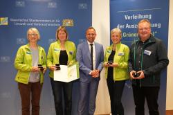 Umweltminister Thorsten Glauber (Mitte) überreichte an die Vertreter von WaldZeit Antje Laux (v.l.), Petra Jehl, Hanni Reischl und Klaus Möller den "Grünen Engel". (Foto: Bayerisches Umweltministerium)