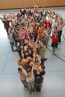 Die dritten und vierten Klassen der beiden Grundschulen stellten sich nach ihrem Aktionstag zum Gruppenfoto in Baumform auf. Schon am Tag zuvor durchliefen die ersten und zweiten Klassen das wilde Programm. (Foto: Sabine Eisch/Nationalpark Bayerischer Wald)